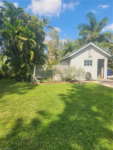 View of home's exterior with fence and a lawn