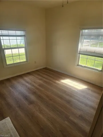Spare room featuring dark wood finished floors and baseboards