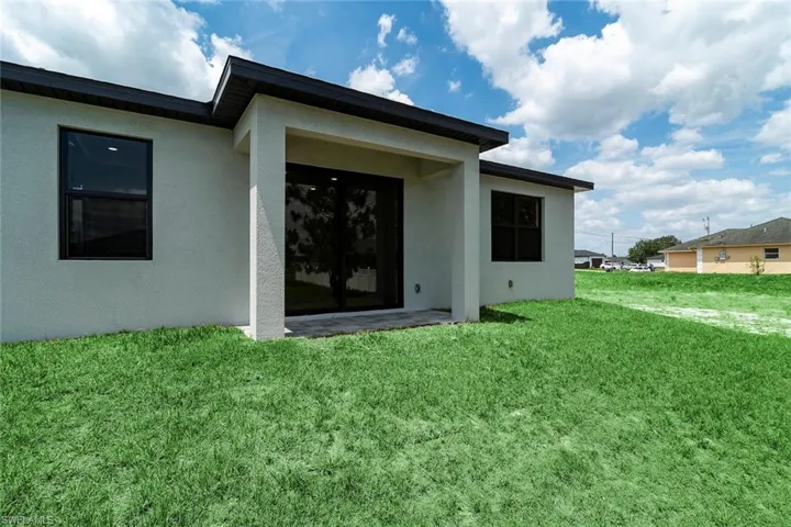 Back of property with a yard, stucco siding, and a patio