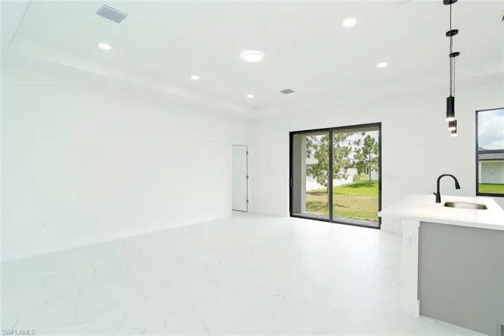 Unfurnished living room with baseboards and recessed lighting