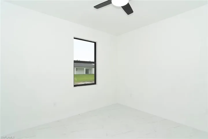 Unfurnished room with marble finish floors and ceiling fan