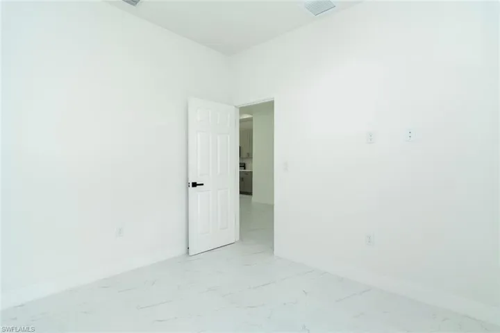 Unfurnished room featuring baseboards and light marble finish flooring