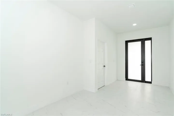 Empty room with recessed lighting and french doors