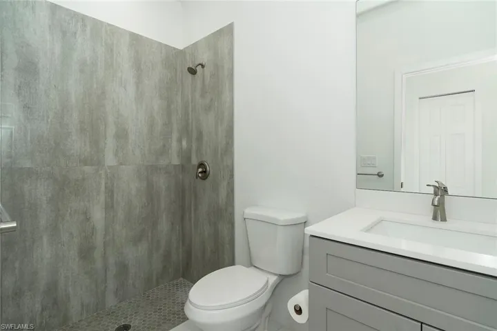 Bathroom with vanity and tiled shower