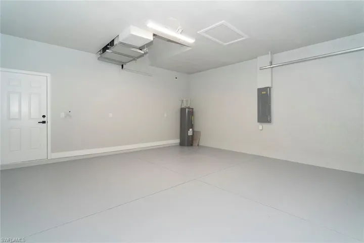 Garage featuring electric panel and water heater