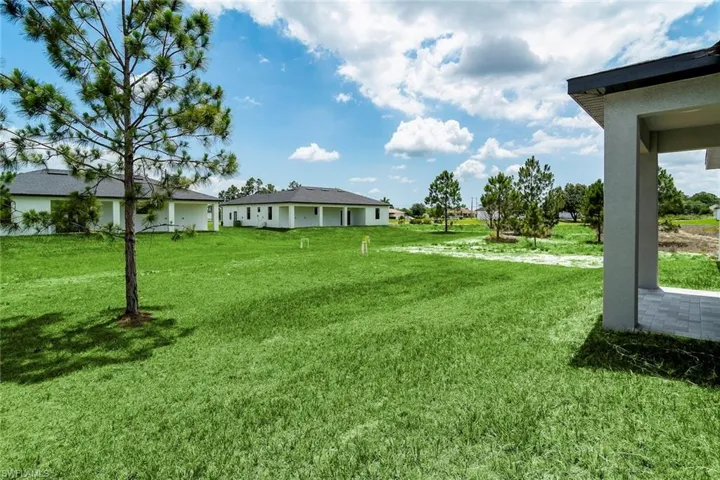 View of grassy yard with a patio area