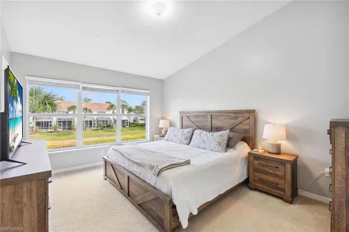Bedroom featuring vaulted ceiling and light colored carpet