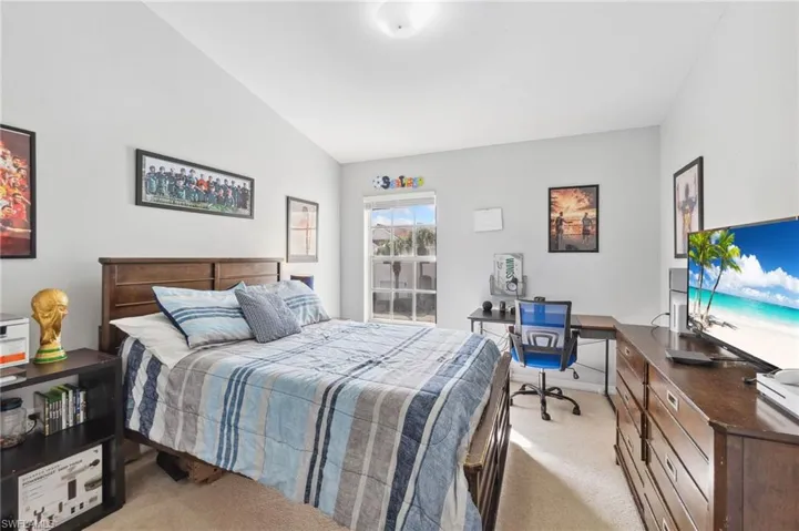 Carpeted bedroom featuring lofted ceiling