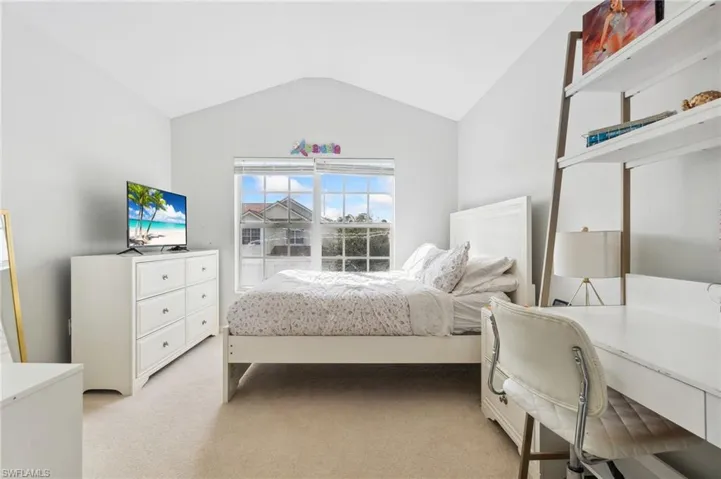 Bedroom featuring light colored carpet and lofted ceiling