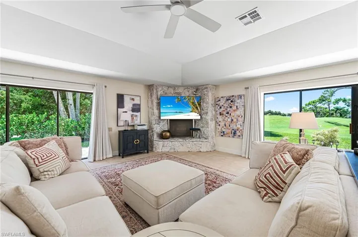 Living room with light Featuring stone fireplace, ceiling fan, and a healthy amount of sunlight