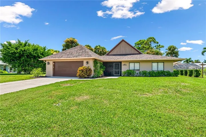 Ranch-style house featuring a 2 car garage and a front yard