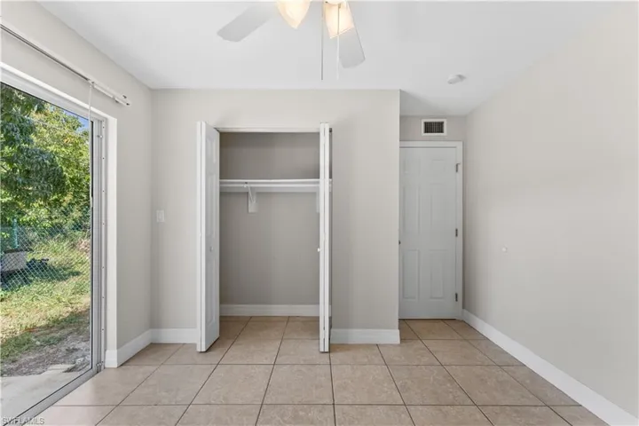 Unfurnished bedroom featuring ceiling fan, a closet, visible vents, light tile patterned flooring, and baseboards