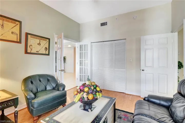 Living room featuring baseboards, visible vents, wood finished floors, and french doors