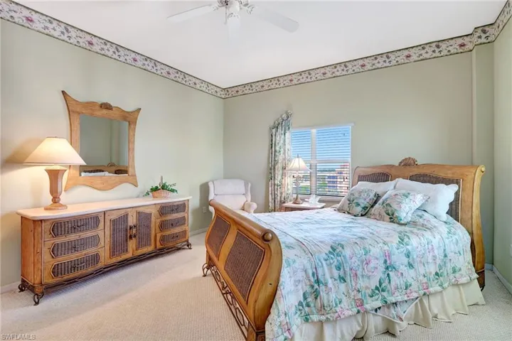 Bedroom featuring baseboards, a ceiling fan, and light carpet