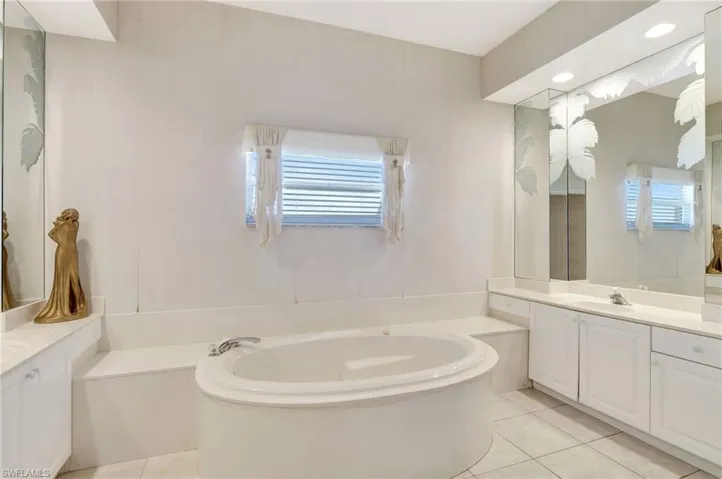 Full bath featuring tile patterned flooring, vanity, and a bath