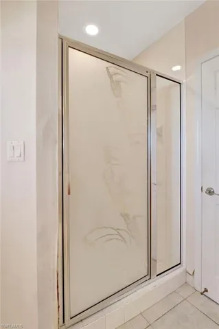 Bathroom featuring a shower stall and tile patterned flooring