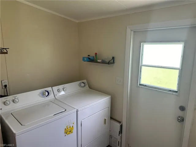 Washroom with washing machine and clothes dryer and crown molding