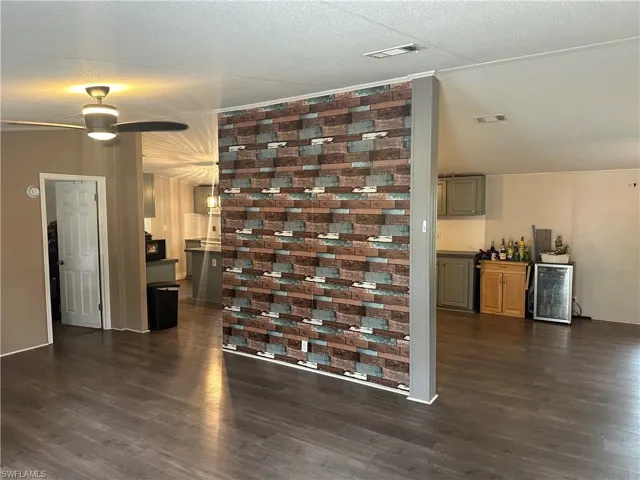 Living room featuring dark wood-type flooring, beverage cooler, and ceiling fan