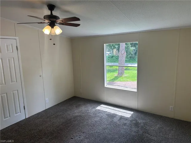 Unfurnished room featuring crown molding, a textured ceiling, ceiling fan, and carpet flooring