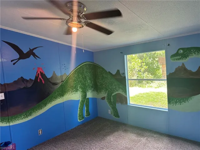 Spare room with ornamental molding, ceiling fan, and carpet floors