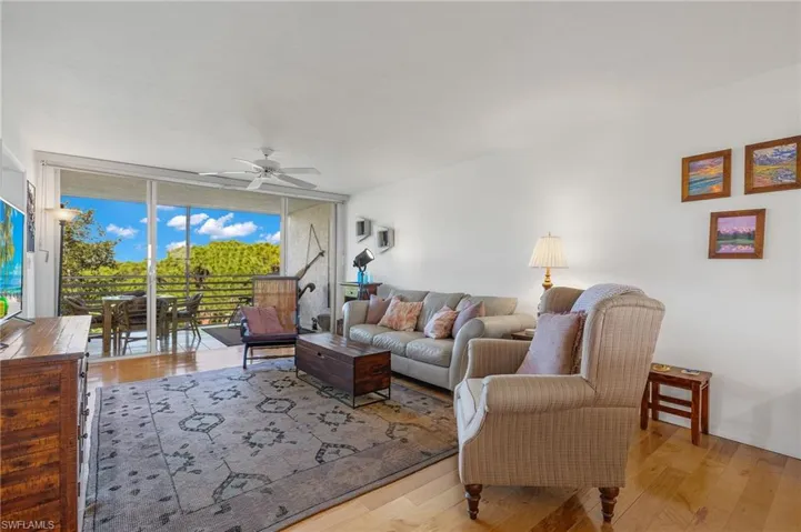 Spacious living area featuring wood-finish flooring and a ceiling fan