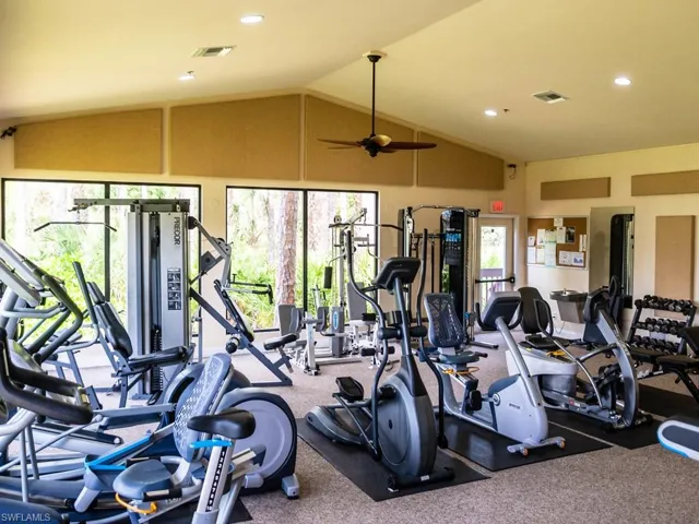 Fitness center featuring a vaulted ceiling with a ceiling fan and recessed lighting