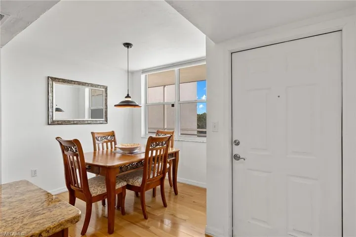 Entryway featuring a paneled door with polished chrome hardware, wood-finish flooring, and a window offering natural light