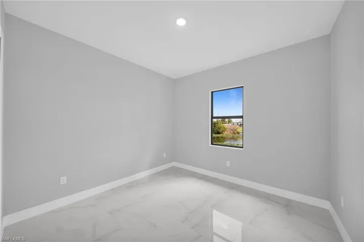 Unfurnished room with light marble finish flooring and baseboards