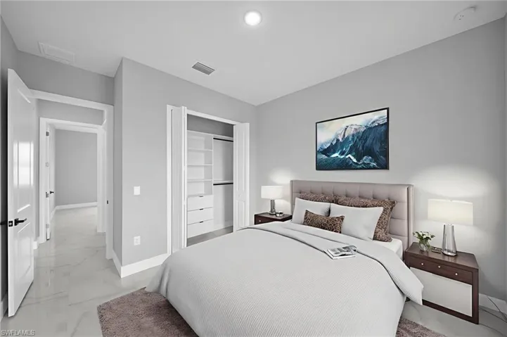 Bedroom with light marble finish floors and a closet