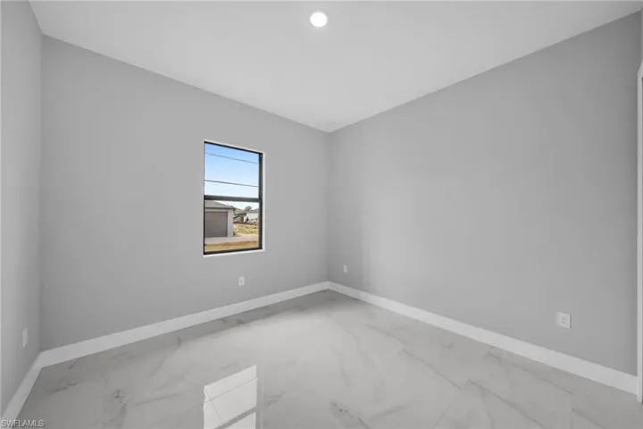 Unfurnished room with light marble finish floors and baseboards