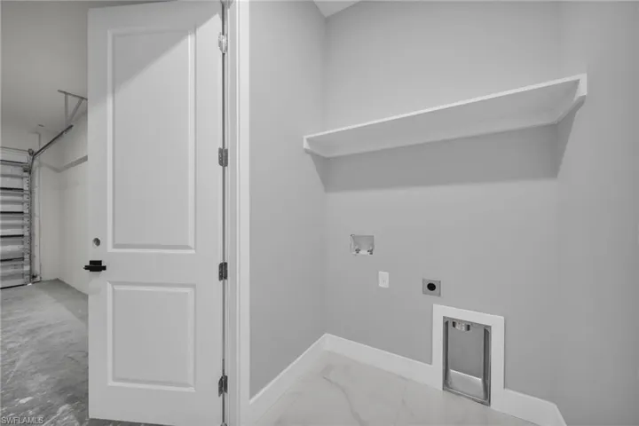 Laundry area featuring washer hookup, hookup for an electric dryer, and light marble finish flooring