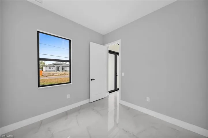 Unfurnished bedroom with baseboards and light marble finish floors