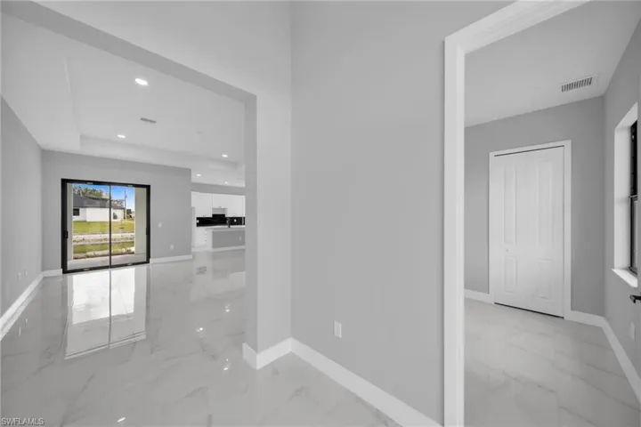 Hall with recessed lighting and light marble finish floors