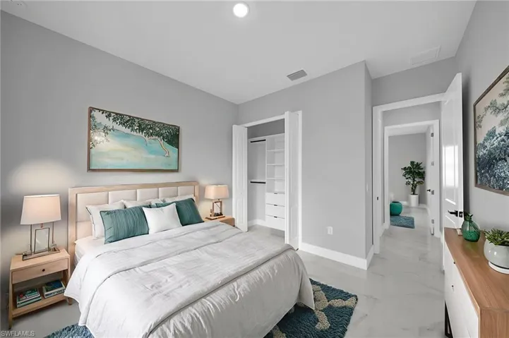Bedroom featuring light marble finish flooring and a closet