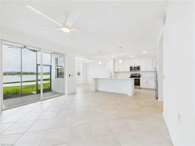 Unfurnished living room with a ceiling fan, light tile patterned floors, and recessed lighting