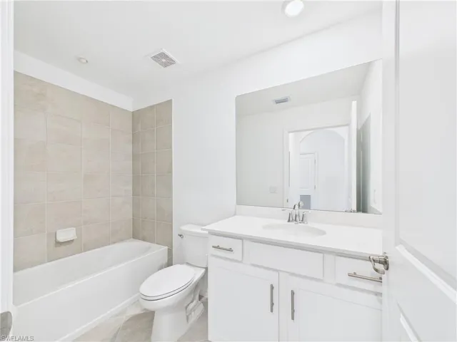 Bathroom with vanity,  shower combination, tile patterned flooring, and recessed lighting