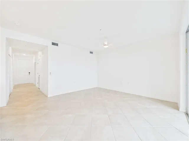Empty room with a ceiling fan and light tile patterned floors