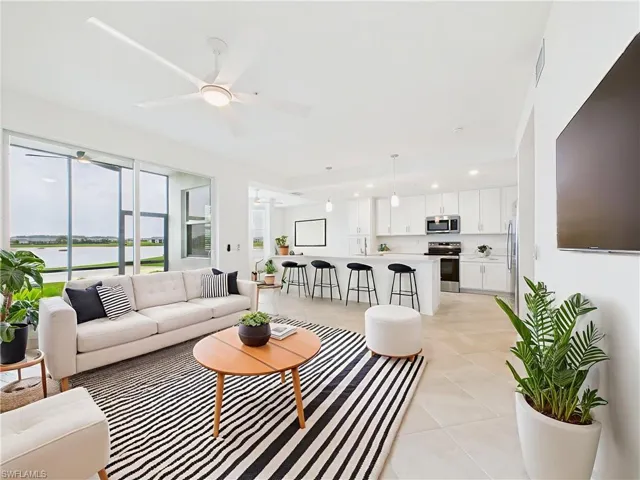 Living room with light tile patterned floors, a ceiling fan, and recessed lighting