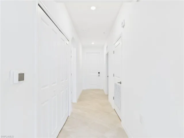 Hall featuring recessed lighting and light tile patterned flooring
