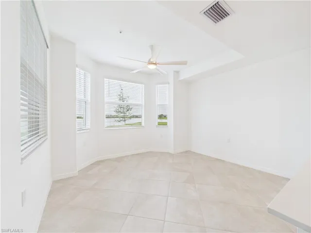 Spare room with a ceiling fan and light tile patterned flooring
