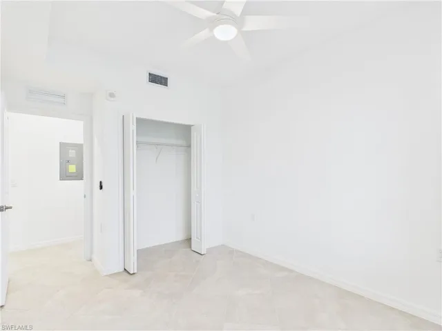 Unfurnished bedroom featuring electric panel, a closet, and ceiling fan