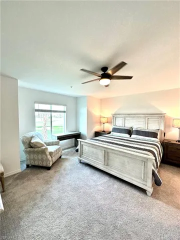 Bedroom with a textured ceiling, carpet flooring, and ceiling fan