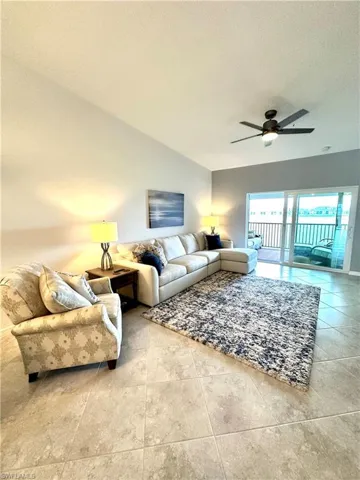 Tiled living room with ceiling fan and a textured ceiling