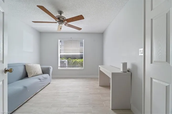 Sitting room with a textured ceiling, ceiling fan, and light wood finished floors