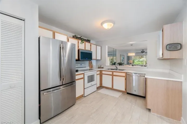 Kitchen featuring stainless steel appliances, light countertops, light wood-type flooring, and light brown cabinets