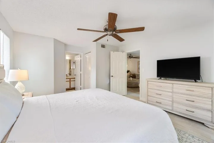 Bedroom featuring ensuite bath and a ceiling fan