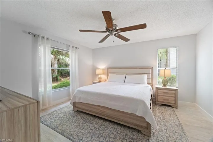 Bedroom with a textured ceiling and ceiling fan