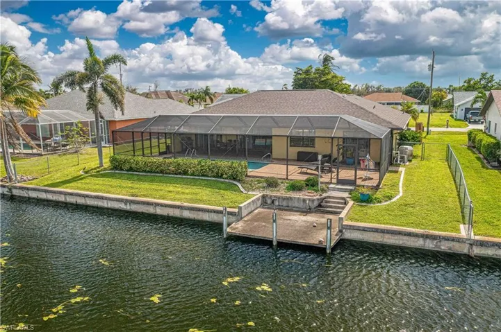 Dock area with a patio, a lanai, a lawn, and a water view