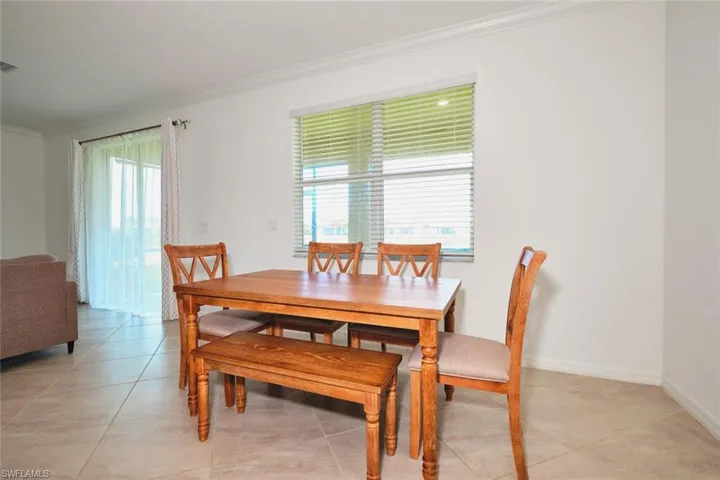 Dining room featuring crown molding and light tile patterned flooring