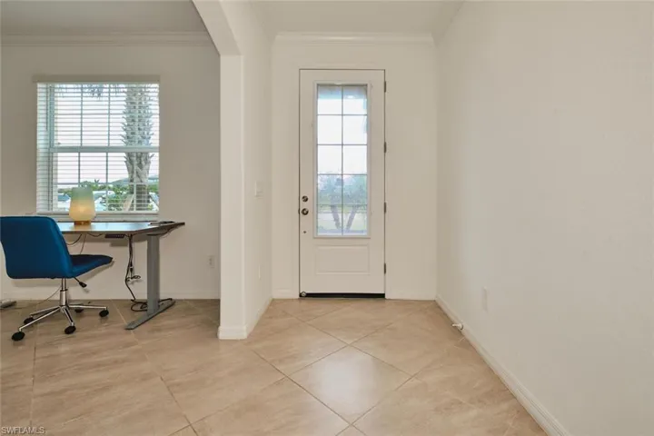 Entryway featuring crown molding, tile patterned flooring, and arched walkways